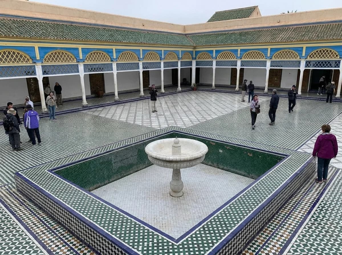 Visitors around the central fountain in the grand marble courtyard of Bahia Palace Marrakech