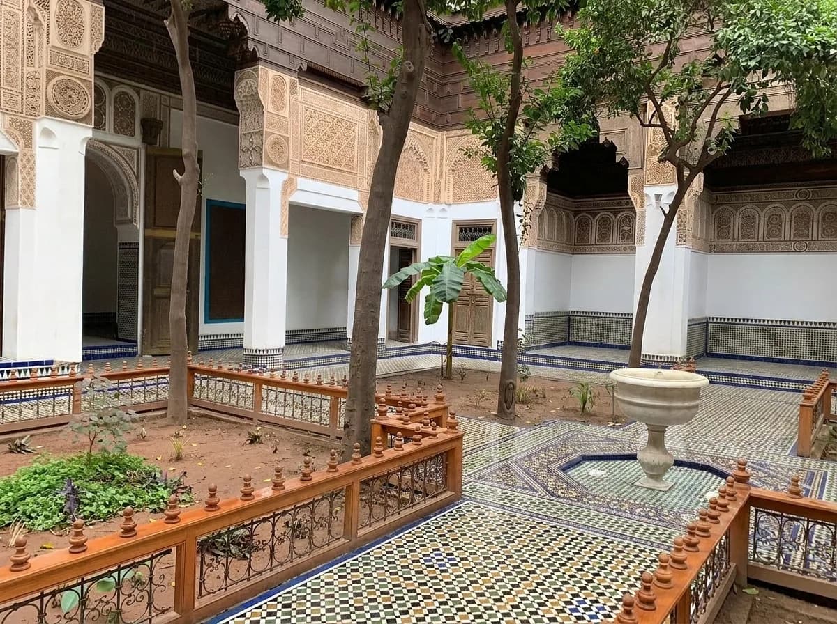 Shaded riad garden courtyard with orange trees and a marble fountain at Bahia Palace Marrakech