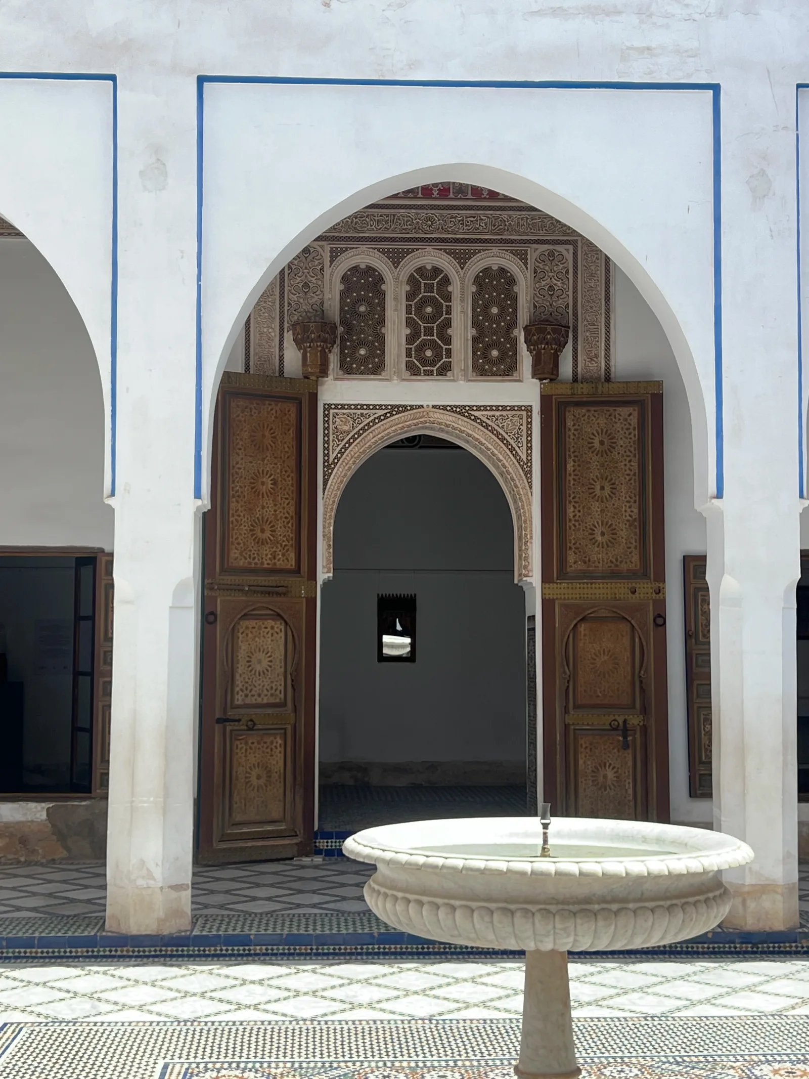 Petite cour de riad avec fontaine centrale et galerie arquée au Palais de la Bahia Marrakech