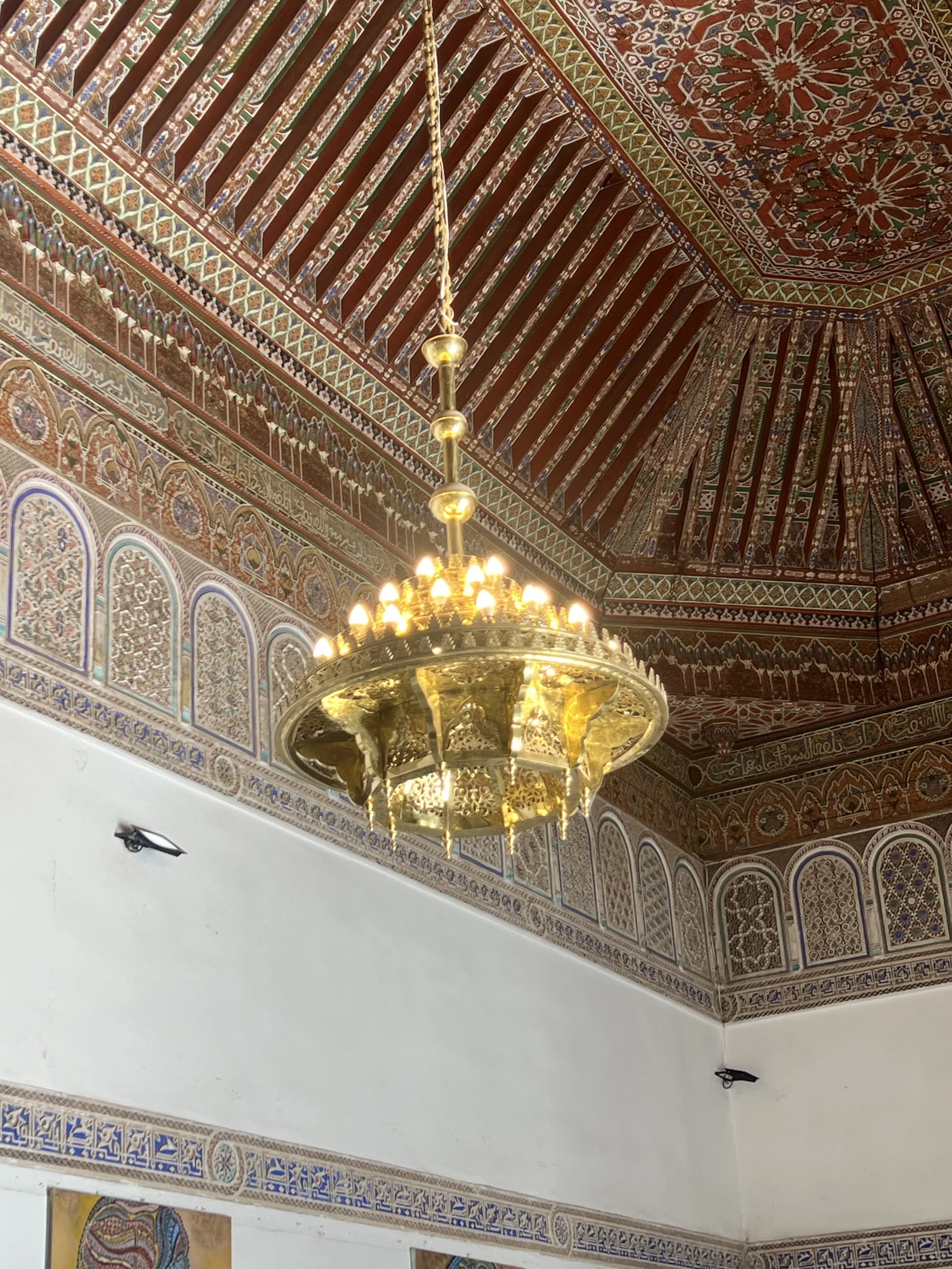 Brass chandelier beneath a painted wooden ceiling, Bahia Palace Marrakech