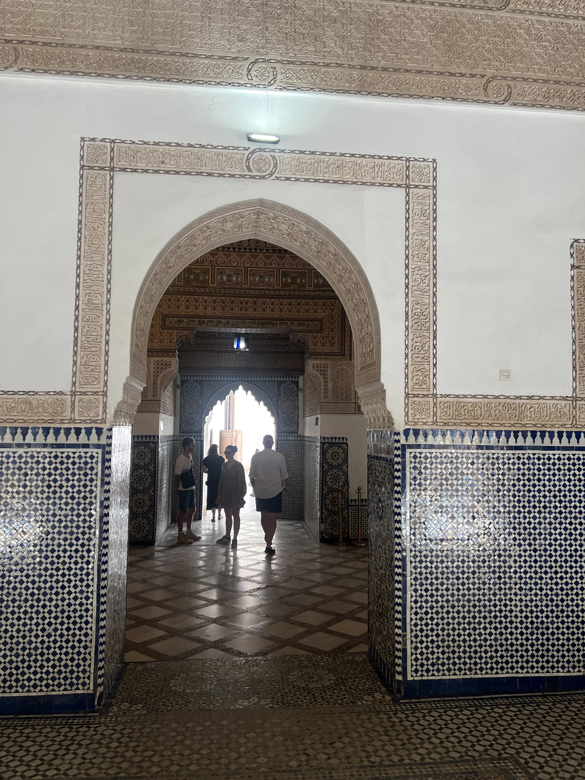 Finely carved stucco archway and zellige walls inside Bahia Palace, Marrakech