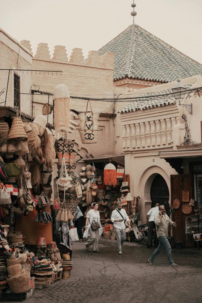Narrow streets of the historic Marrakech Medina filled with traditional shops, local markets, and authentic Moroccan architecture — Palais de la Bahia Marrakech