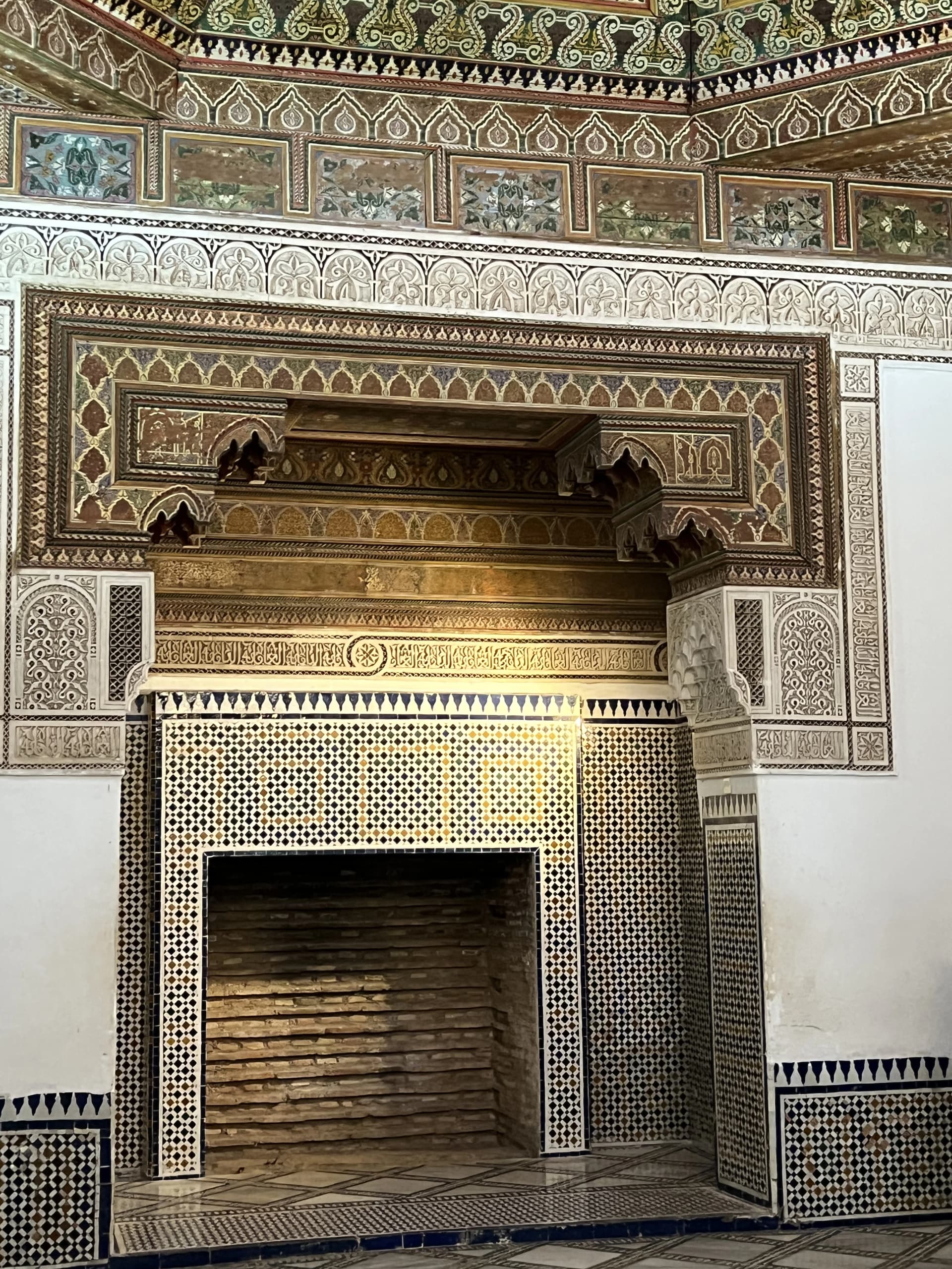 Ornate Moroccan fireplace with intricate zellige tilework inside Bahia Palace Marrakech