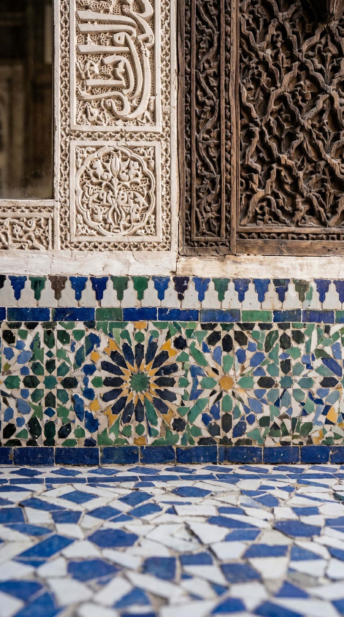 Bahia Palace zellige mosaic tiles blue green pattern with Arabic calligraphy stucco panel
